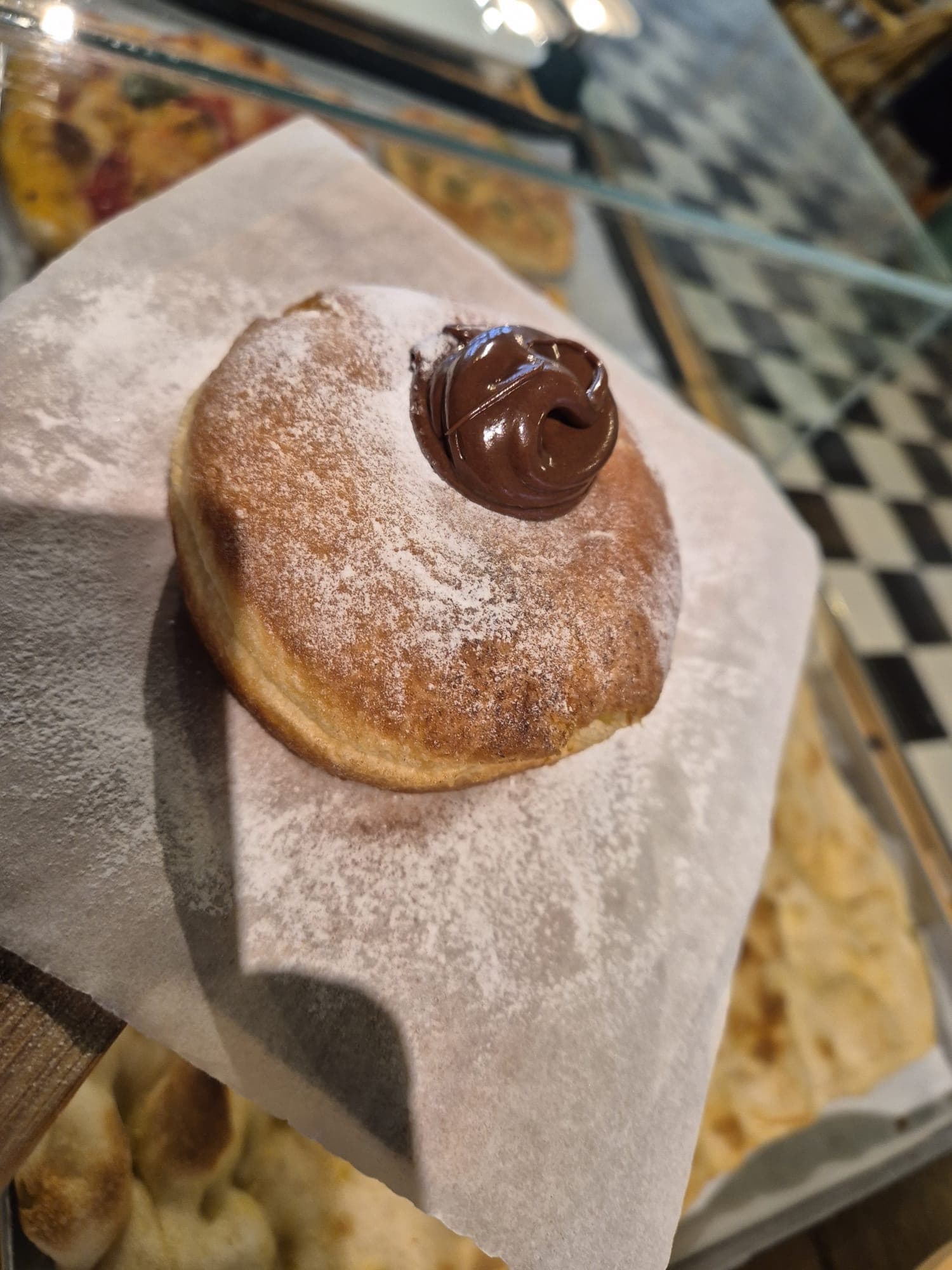 Bombolone met chocoladevulling en poedersuiker, vers uit de keuken