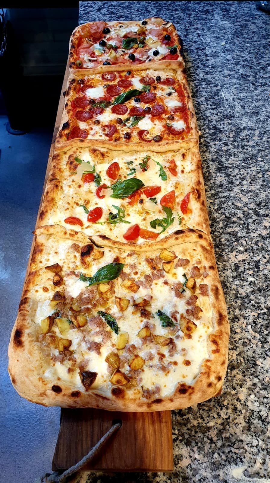 Vier lange pizza al taglio op een houten plank, vers uit de oven